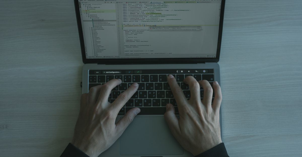 Close-up view of a programmer coding on a laptop, showcasing modern software development.
